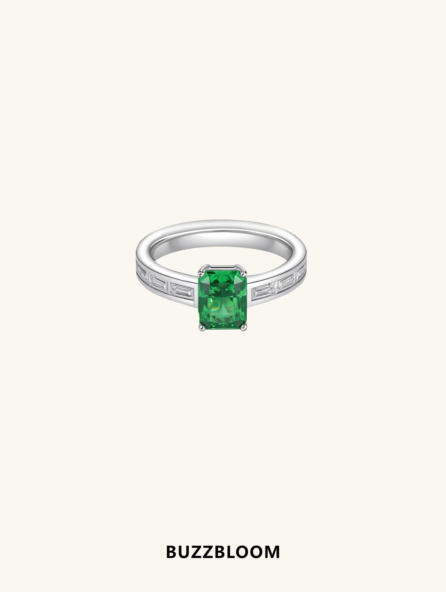 BuzzBloom ring with emerald-cut green center stone and tapered baguette side diamonds, front view