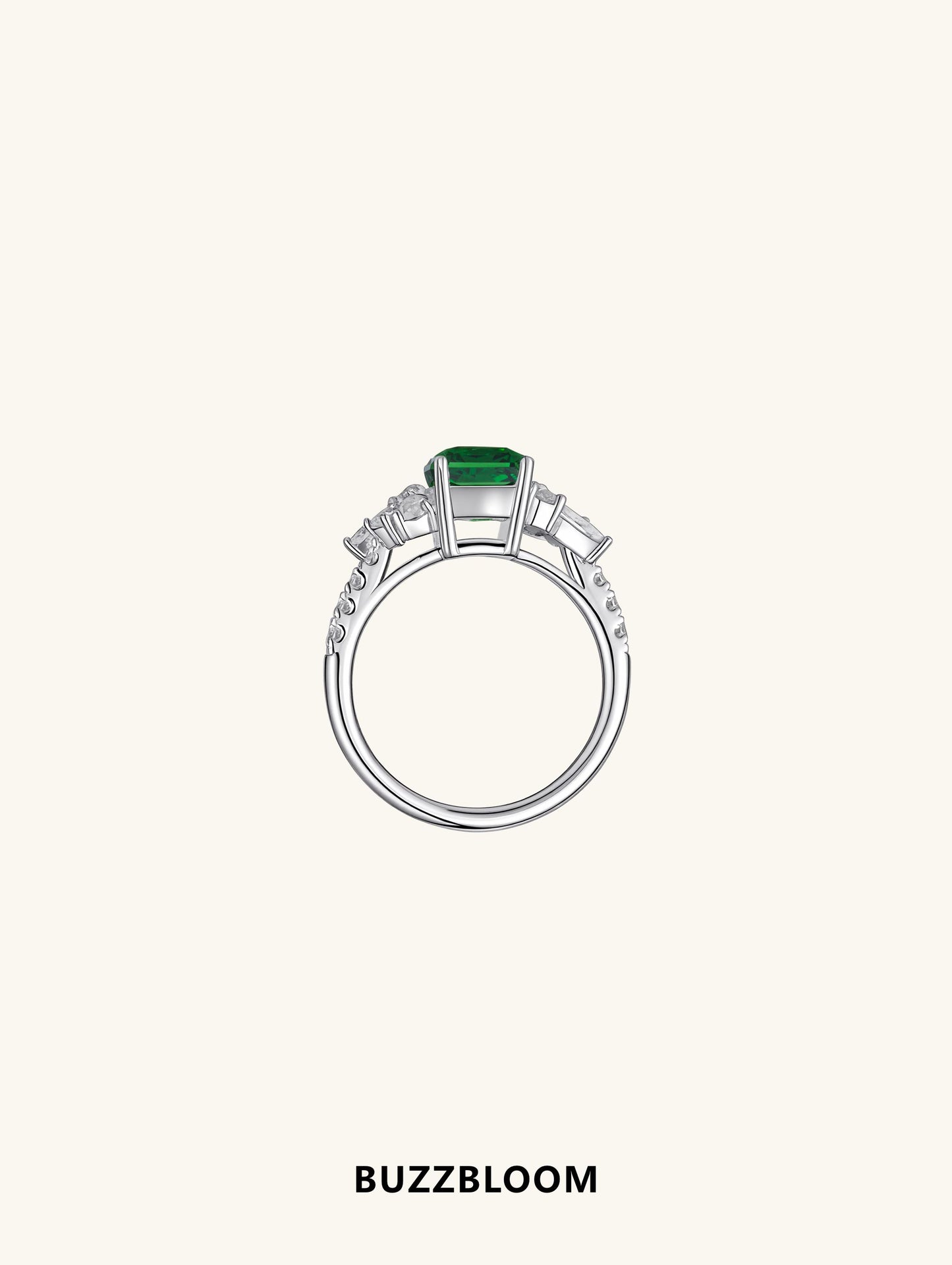 Angled view of BuzzBloom emerald cluster ring showing diamond side accents