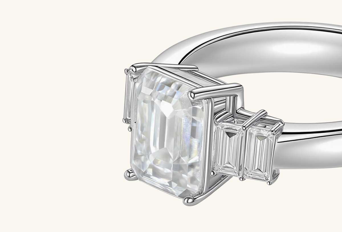 Macro view of BuzzBloom emerald cut diamond showing step-cut facets and baguette side stones.