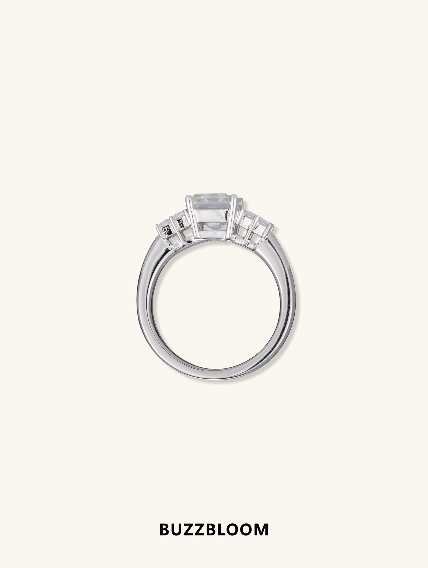 Side profile of BuzzBloom emerald cut diamond engagement ring in white gold with baguette accents.