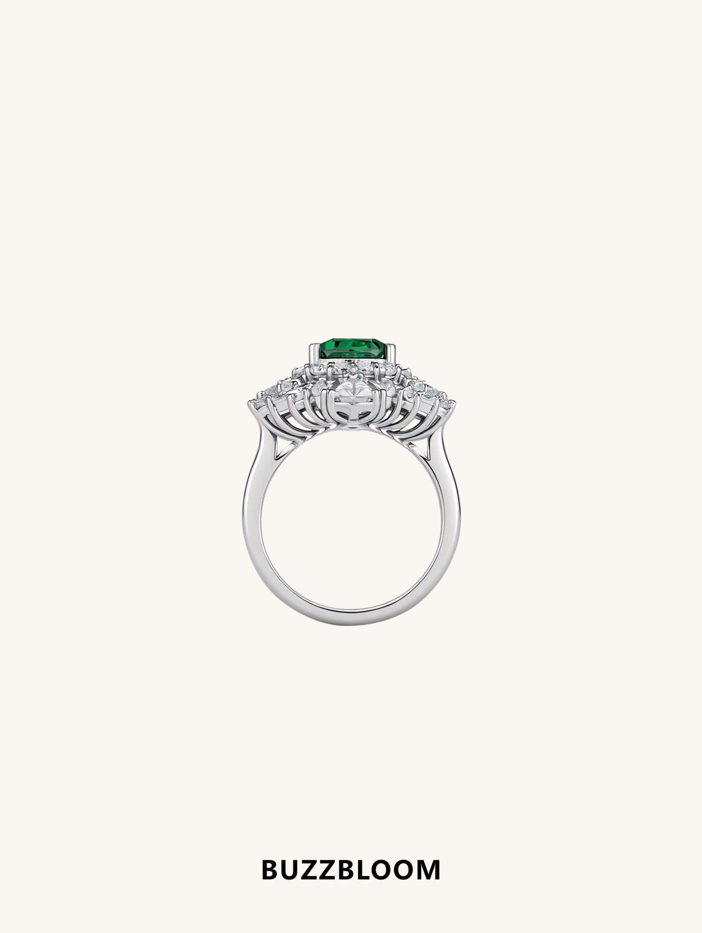 Side profile of BuzzBloom emerald halo ring showing basket setting and halo detail