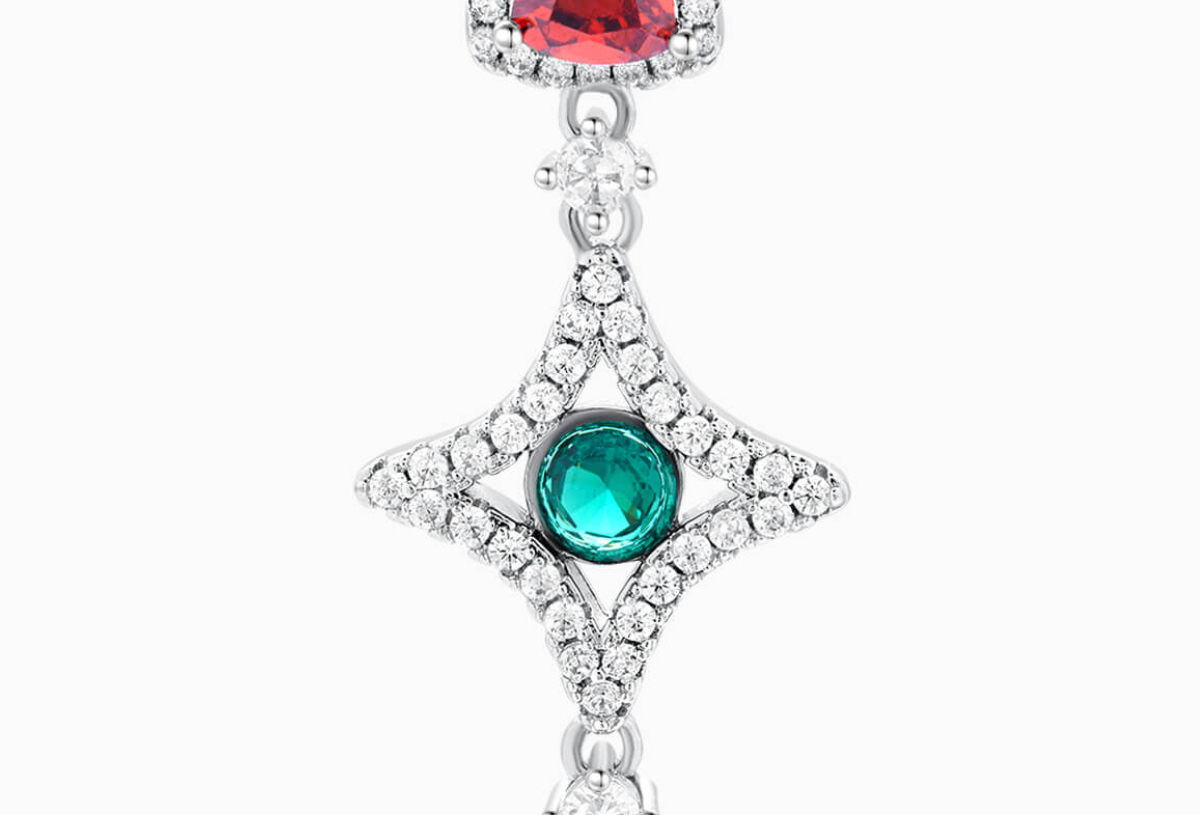 Close-up detail of BuzzBloom pavé diamond necklace with emerald and ruby.