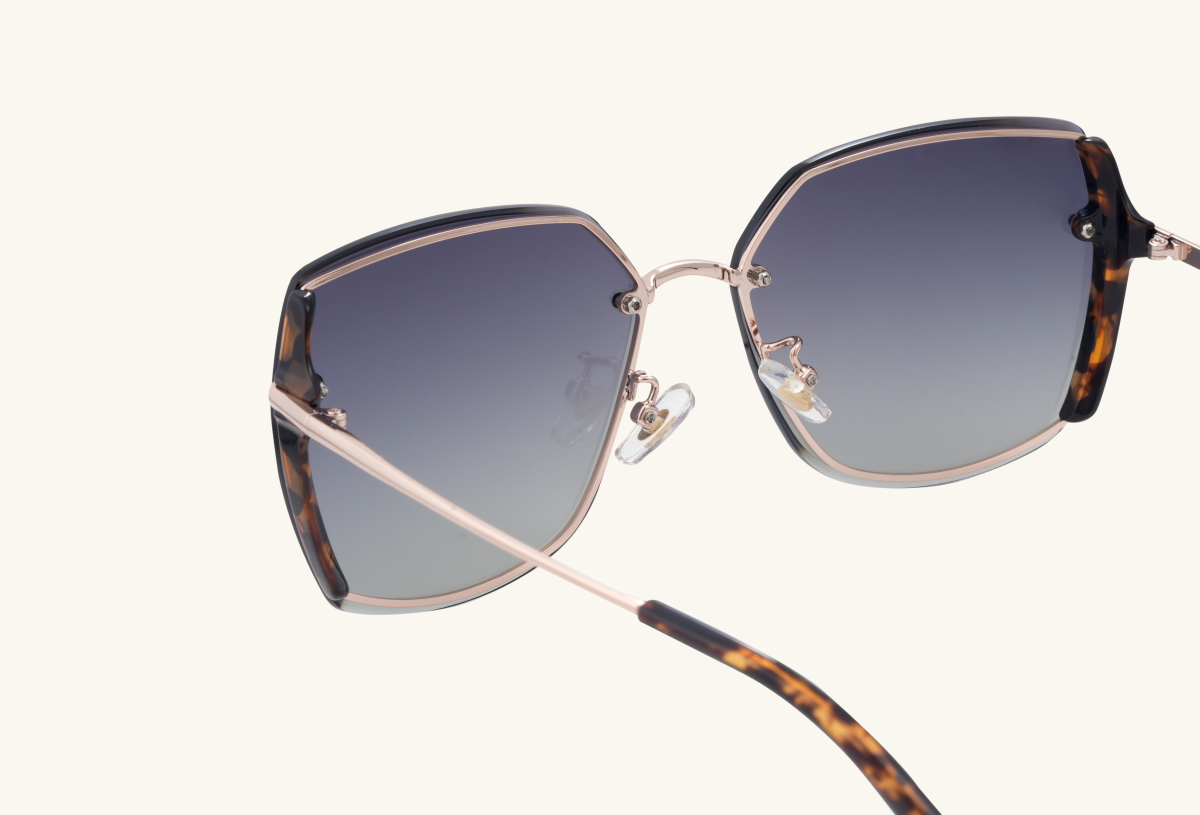 Side arm and hinge detail of BuzzBloom oversized square sunglasses.