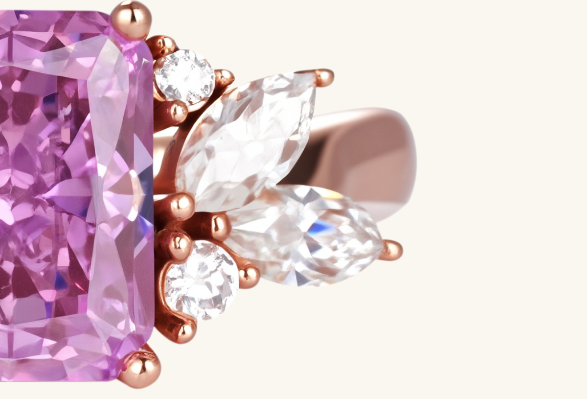 Close-up of BuzzBloom rose gold ring prong setting holding pink sapphire.